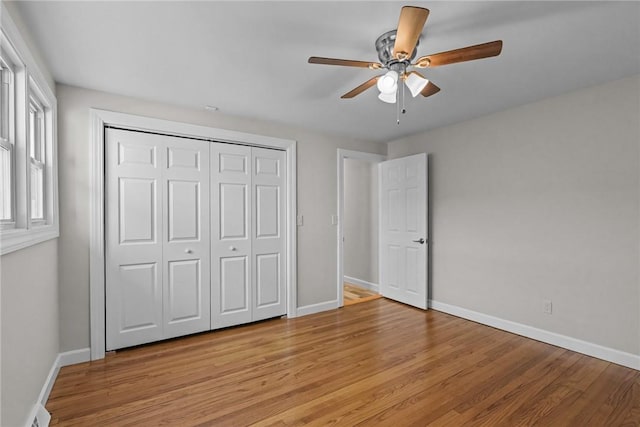 unfurnished bedroom featuring a closet, ceiling fan, and light hardwood / wood-style flooring