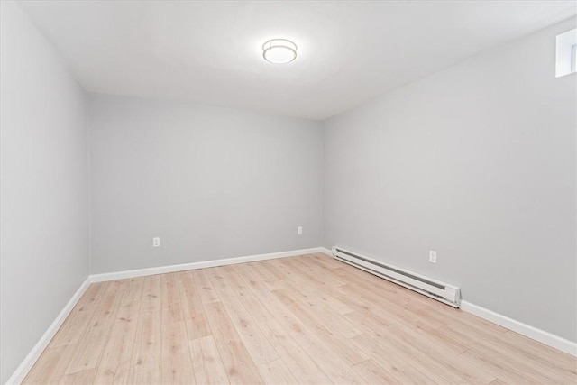 unfurnished room with a baseboard radiator and light hardwood / wood-style floors