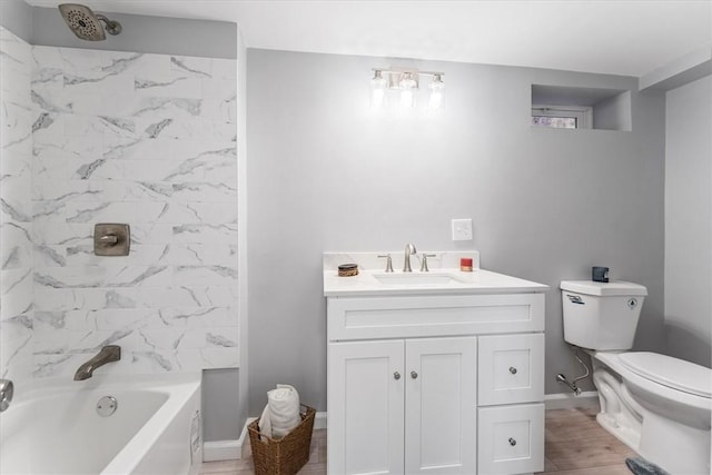 full bathroom with vanity, wood-type flooring, toilet, and tiled shower / bath