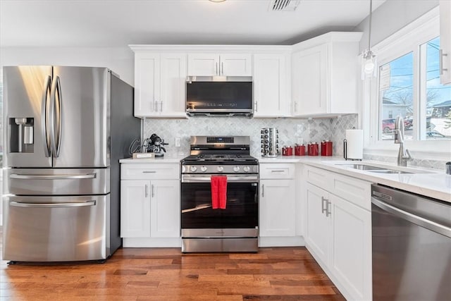 kitchen featuring white cabinetry, stainless steel appliances, sink, and hardwood / wood-style flooring