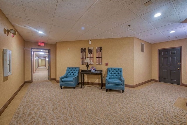 sitting room featuring light colored carpet and a drop ceiling