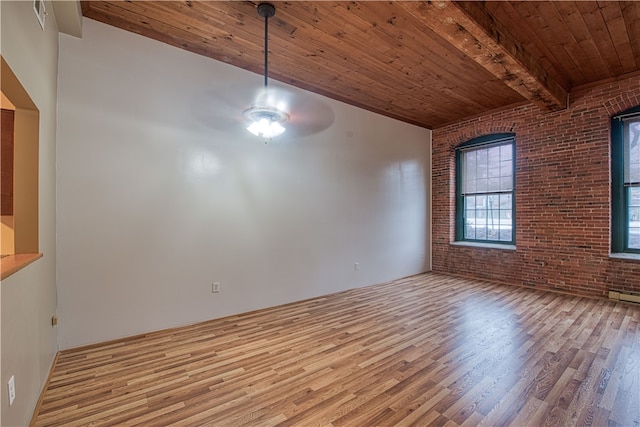 unfurnished dining area featuring wood ceiling, light wood-type flooring, ceiling fan, brick wall, and beam ceiling