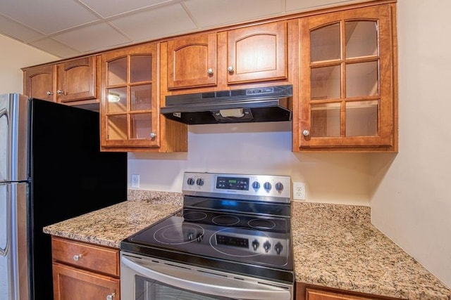 kitchen with a drop ceiling, light stone countertops, and stainless steel appliances