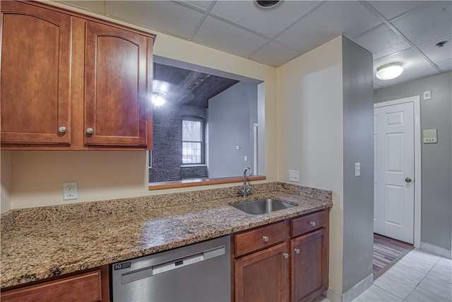 kitchen with sink, a paneled ceiling, light stone countertops, and dishwasher