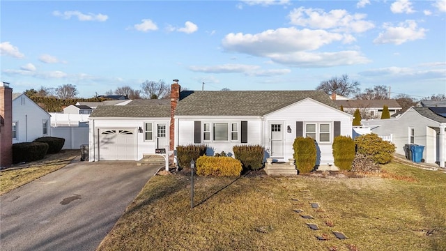 ranch-style home featuring a garage and a front lawn