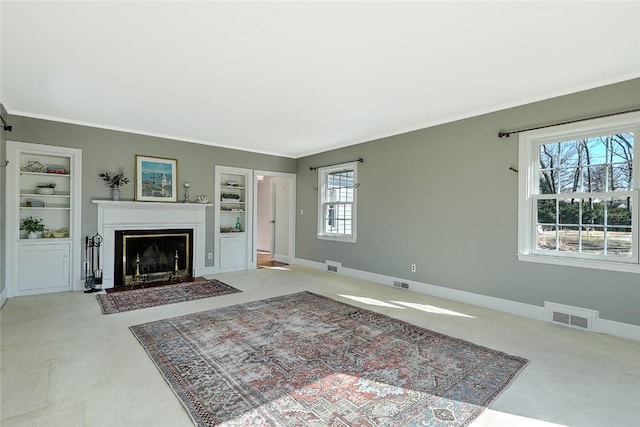 living area featuring baseboards, built in shelves, and visible vents