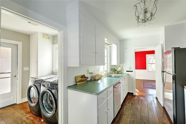 kitchen with separate washer and dryer, a sink, white cabinets, appliances with stainless steel finishes, and dark wood-style floors