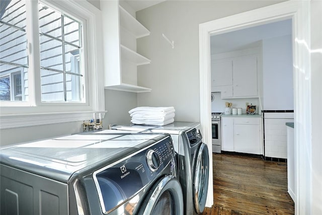 washroom with laundry area, washing machine and dryer, and dark wood finished floors