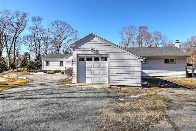 exterior space featuring driveway and a chimney