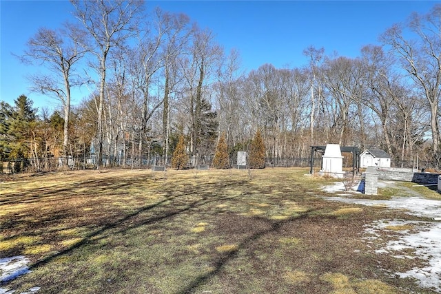 view of yard with fence, a storage unit, and an outbuilding