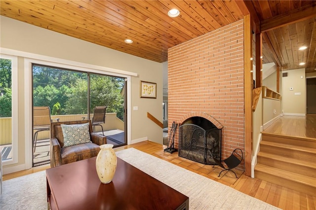 living room featuring a brick fireplace, wooden ceiling, and light hardwood / wood-style flooring