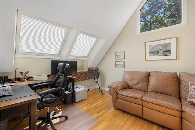 office with lofted ceiling and light wood-type flooring