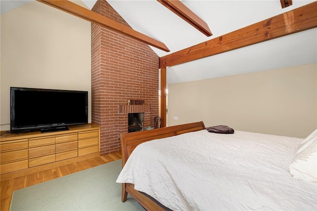 bedroom featuring vaulted ceiling with beams, wood-type flooring, and a brick fireplace