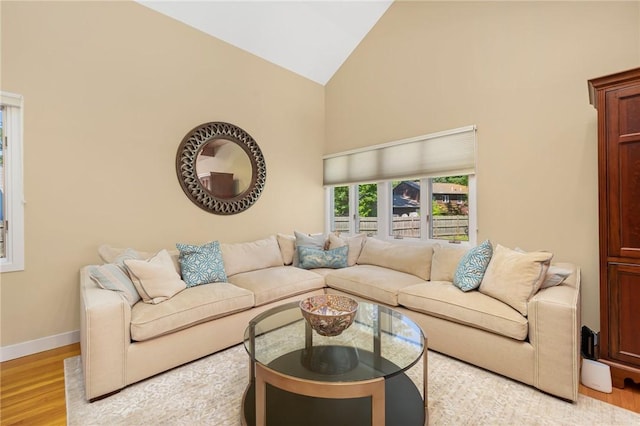 living room featuring high vaulted ceiling and light wood-type flooring