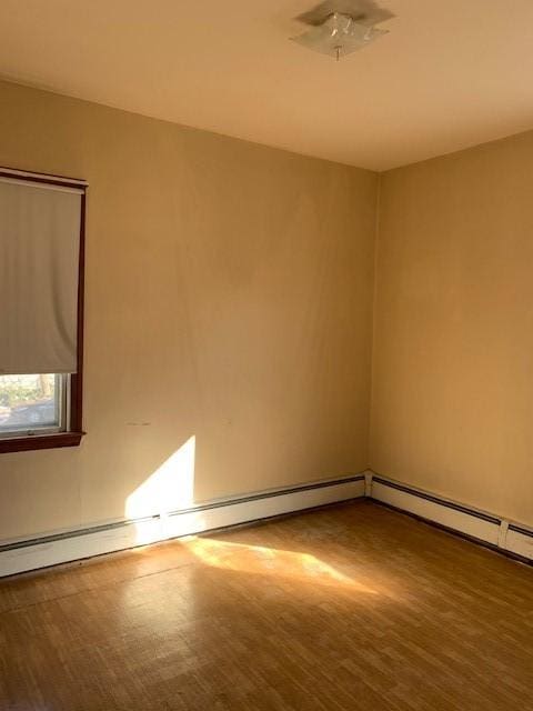 spare room with hardwood / wood-style flooring and baseboard heating