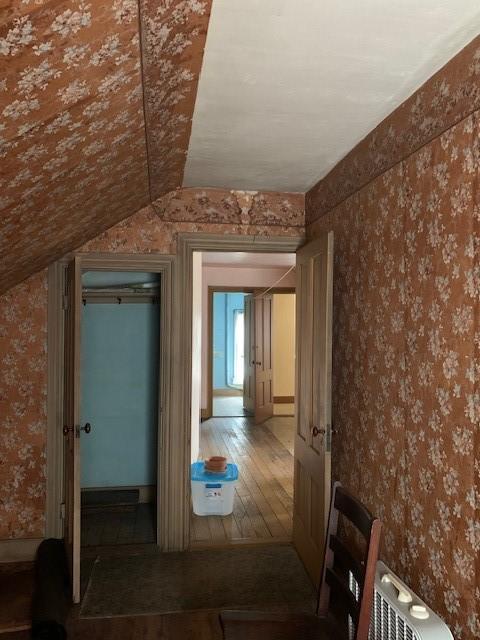 hallway featuring lofted ceiling and hardwood / wood-style floors