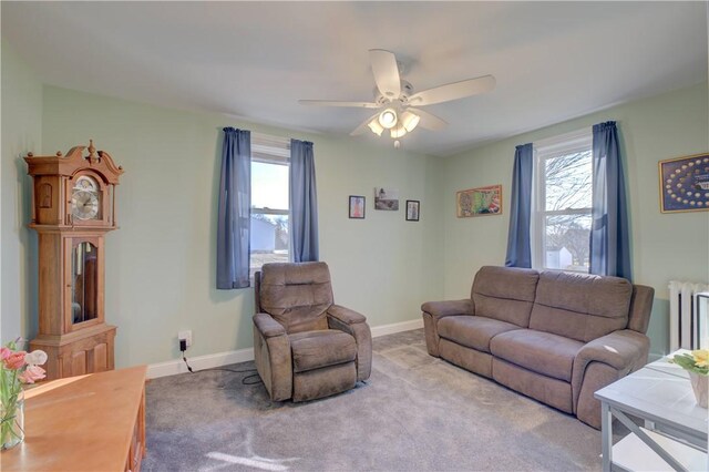 carpeted living room featuring radiator heating unit, a wealth of natural light, and ceiling fan