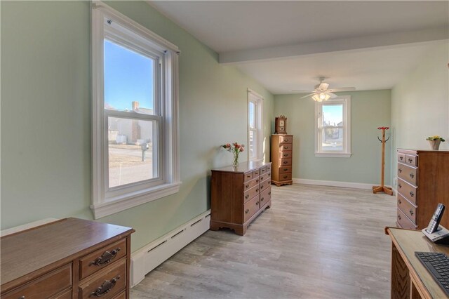 living area with ceiling fan, light wood-type flooring, and a baseboard heating unit