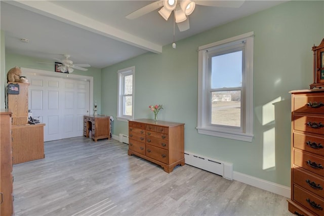 bedroom featuring a baseboard heating unit, beam ceiling, and light hardwood / wood-style floors