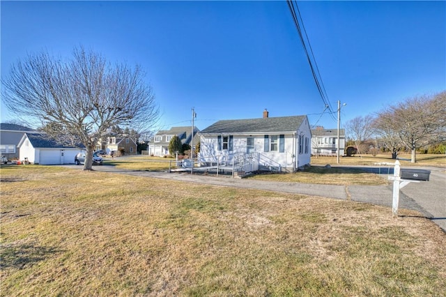 bungalow-style house with a chimney and a front lawn