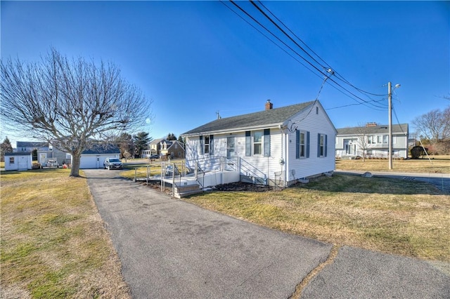 view of front of home with a chimney and a front yard