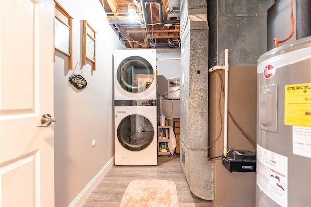 clothes washing area featuring stacked washer and dryer, electric water heater, and light hardwood / wood-style floors