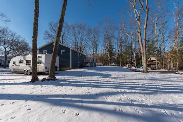 yard covered in snow featuring a playground