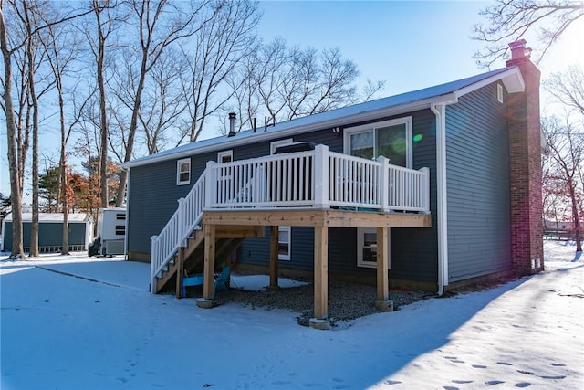 snow covered house with a deck