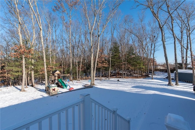 yard covered in snow featuring a playground