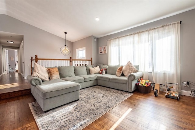 living room featuring vaulted ceiling and wood-type flooring