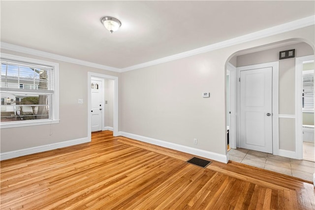 spare room with ornamental molding and light hardwood / wood-style flooring