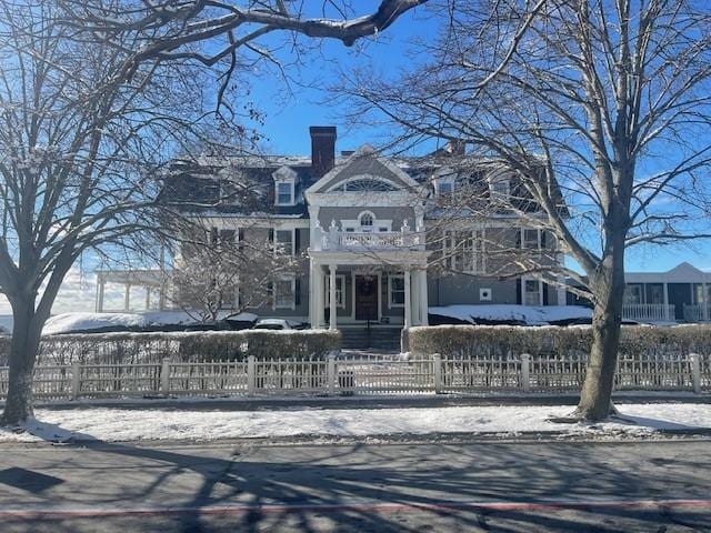 snow covered building featuring a fenced front yard