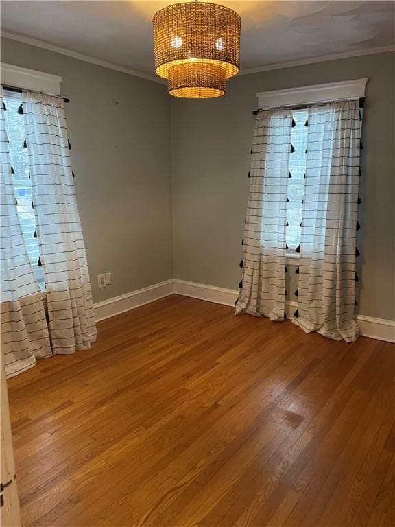 empty room featuring ornamental molding and wood-type flooring