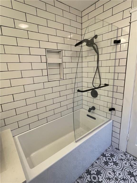 bathroom featuring tiled shower / bath combo and tile patterned flooring