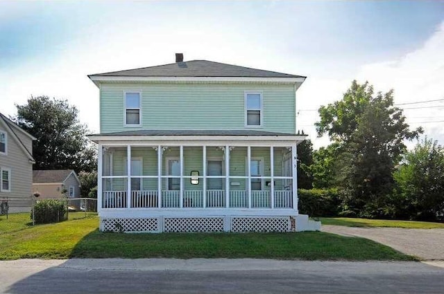 back of house featuring a sunroom and a lawn