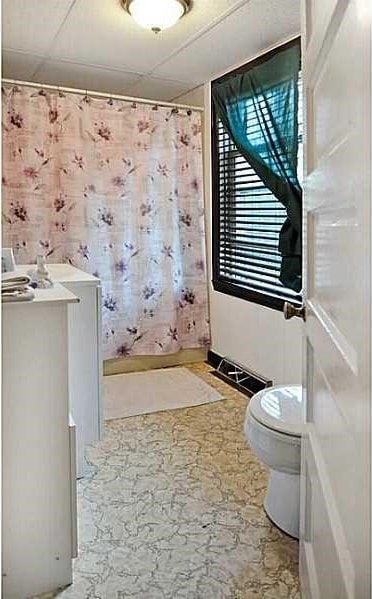 bathroom featuring walk in shower and toilet