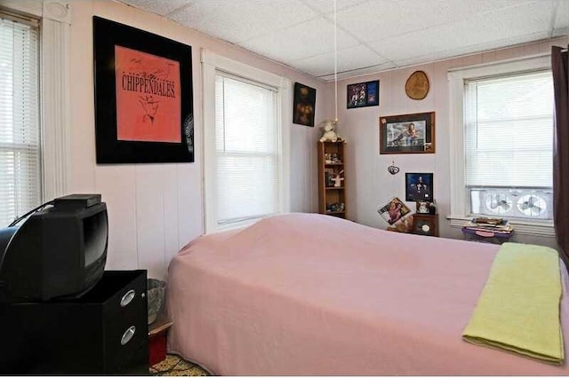 bedroom with multiple windows and a paneled ceiling