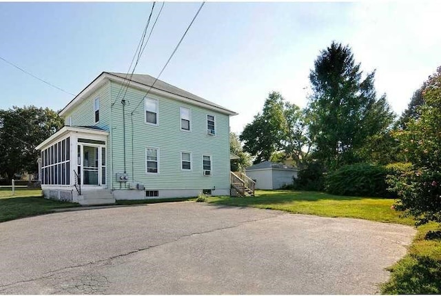 rear view of property with a yard and a sunroom