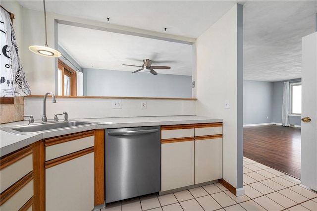 kitchen featuring dishwasher, sink, white cabinets, light tile patterned floors, and ceiling fan