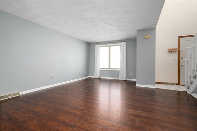 unfurnished room with dark hardwood / wood-style flooring