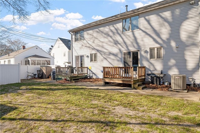 back of house with a wooden deck, a lawn, and central air condition unit