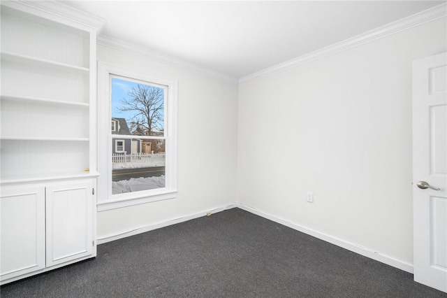 unfurnished room featuring ornamental molding and dark colored carpet