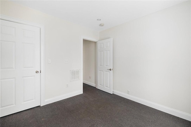 unfurnished bedroom featuring dark carpet