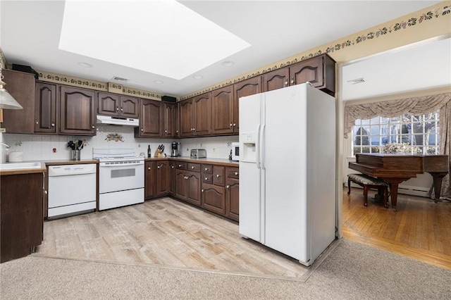 kitchen with sink, white appliances, dark brown cabinets, and decorative backsplash