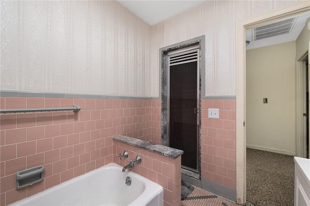 bathroom featuring a bathtub and tile walls