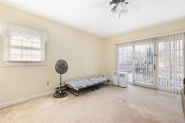 interior space featuring ceiling fan, light carpet, and a baseboard heating unit