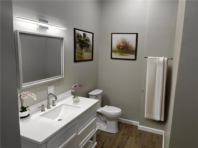 bathroom with hardwood / wood-style flooring, vanity, and toilet