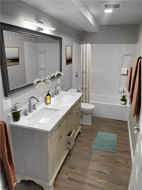 full bathroom with hardwood / wood-style flooring, vanity, tub / shower combination, and toilet