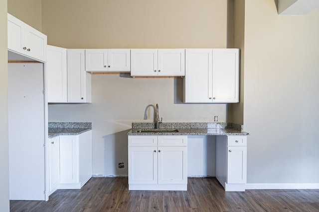 kitchen with white cabinetry, stone countertops, dark hardwood / wood-style flooring, and sink