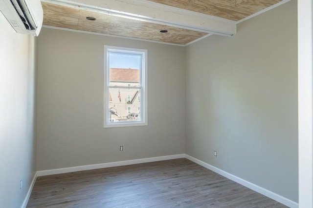 spare room with ornamental molding, an AC wall unit, and light wood-type flooring